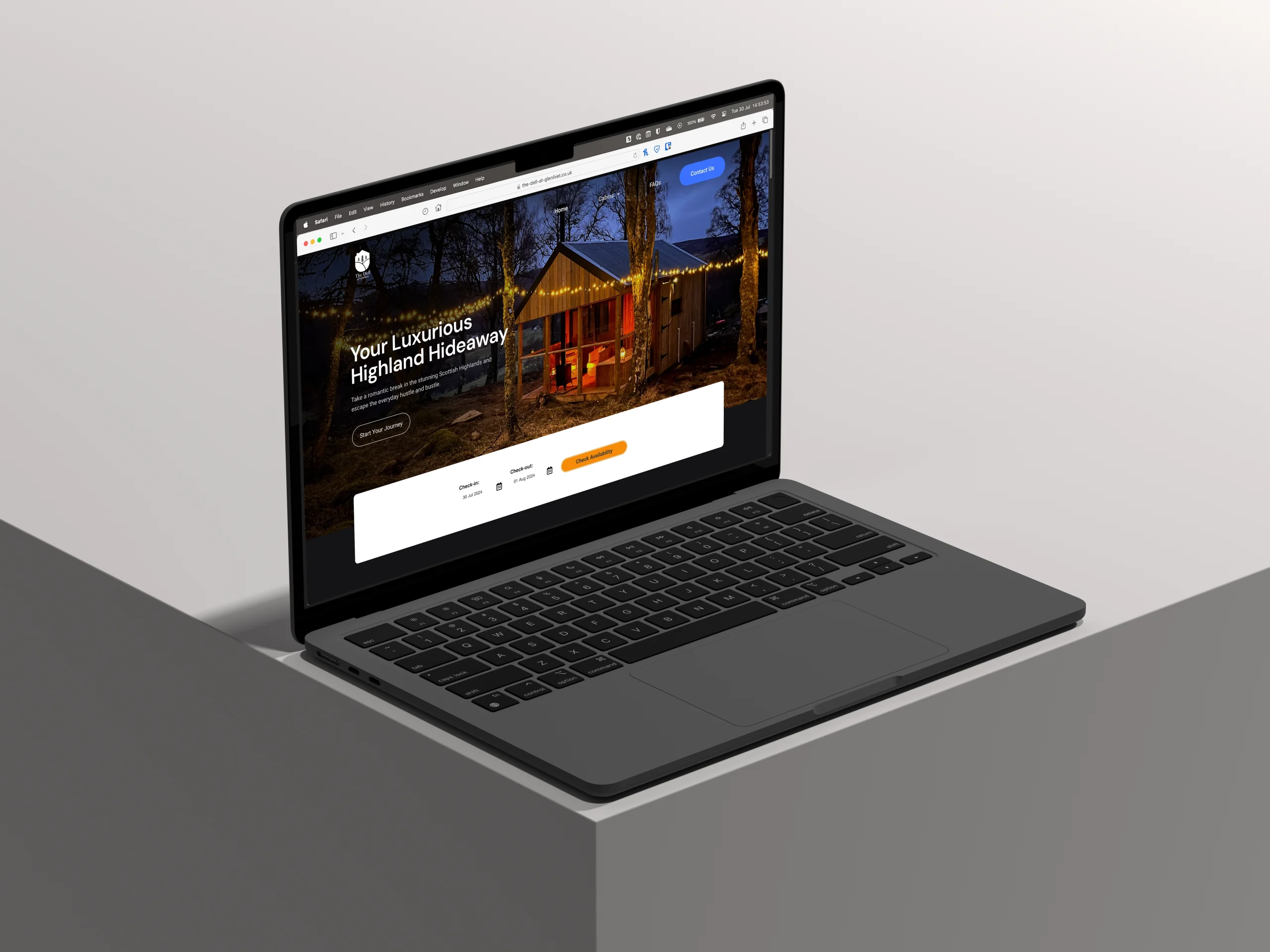 A laptop displaying a website for a luxurious Highland hideaway with an image of a wooden cabin lit at night.